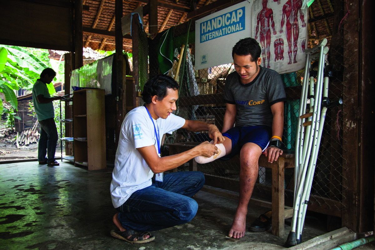 Jonge man, slachtoffer van landmijn, verzorgd door HI in Birmese kampen in Thailand