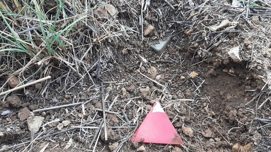 Gevonden Israëlische antipersoonsmijn en aangeduid met een rode driehoek door het HI-ontmijningsteam in het dorp Btater in het Libanese district Aley.