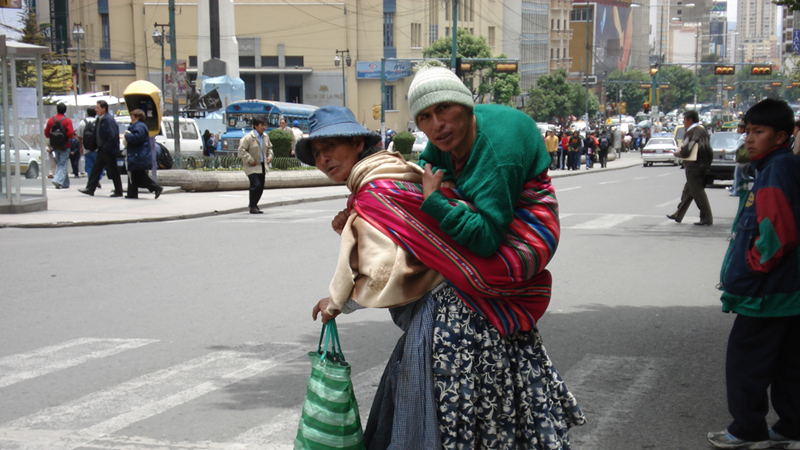 Persoon met een handicap wordt gedragen doorhet centrum van La Paz