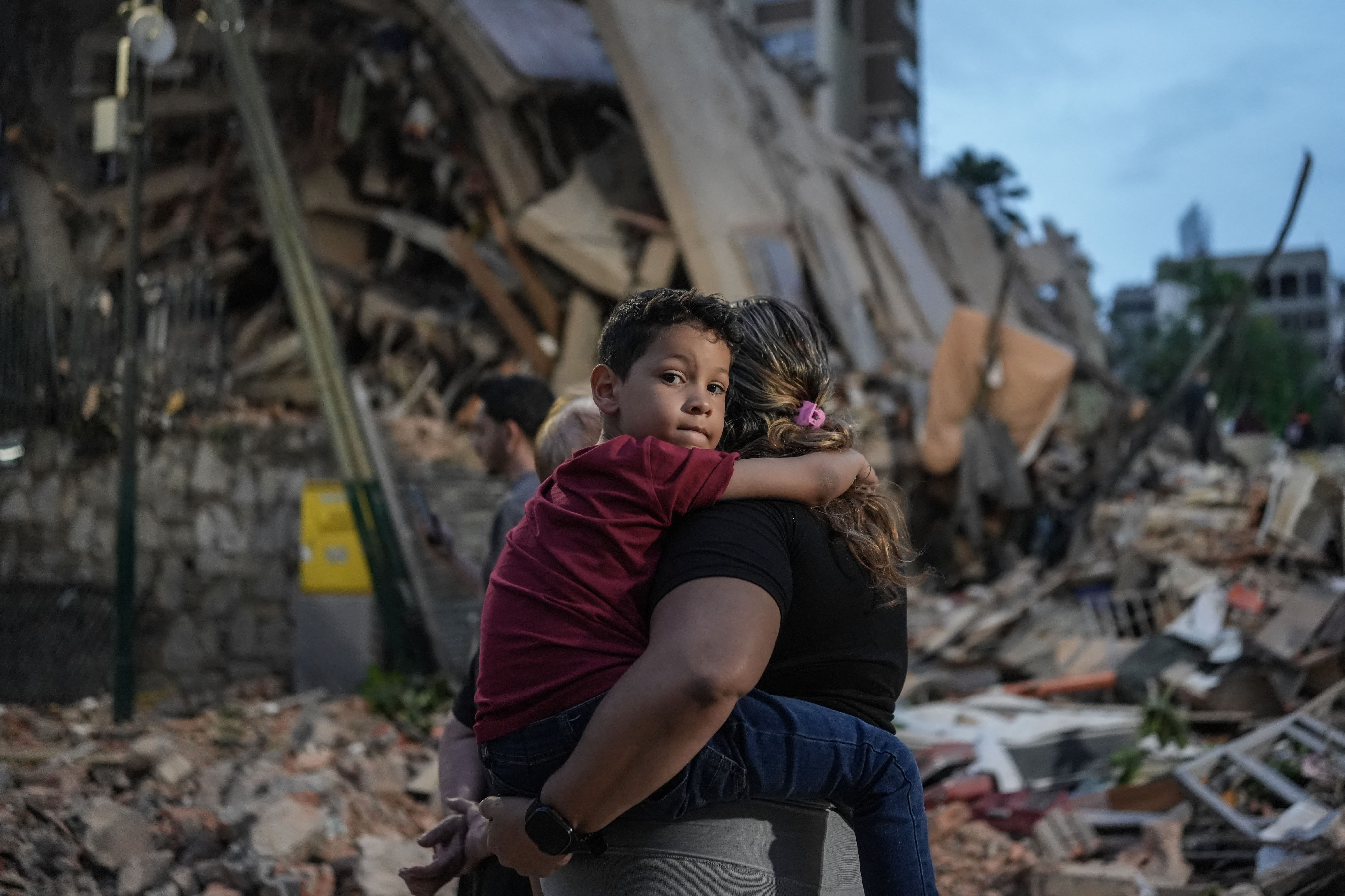 Mensen lopen langs een ingestort gebouw na een aardbeving in Caracas op 25 juni 2026.
