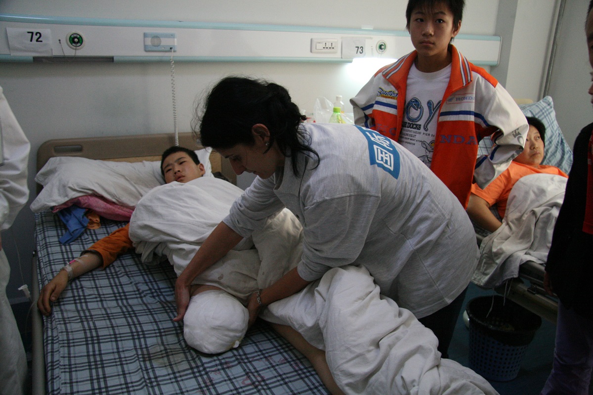 Graziella Lippolis, Rehabilitation Manager, examine un patient lors du tremblement de terre au Sichuan.