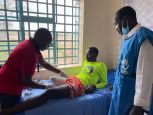 Andrew Mwangi (links) laat de 17-jarige Gatkuoth zien hoe hij zijn geamputeerde been op de juiste wijze moet omwikkelen in één van de revalidatiecentra van HI in het vluchtelingendorp Kakuma.