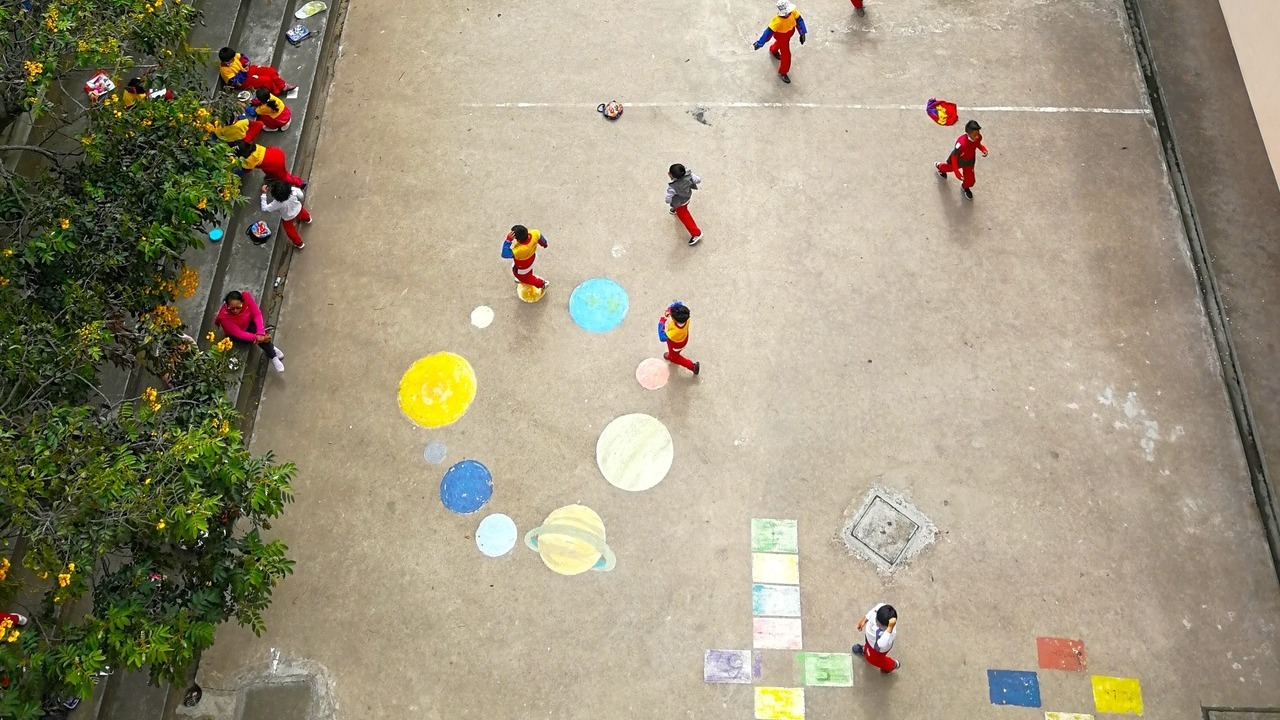 Luchtfoto van een speelplaats waar kinderen aan het spelen zijn.