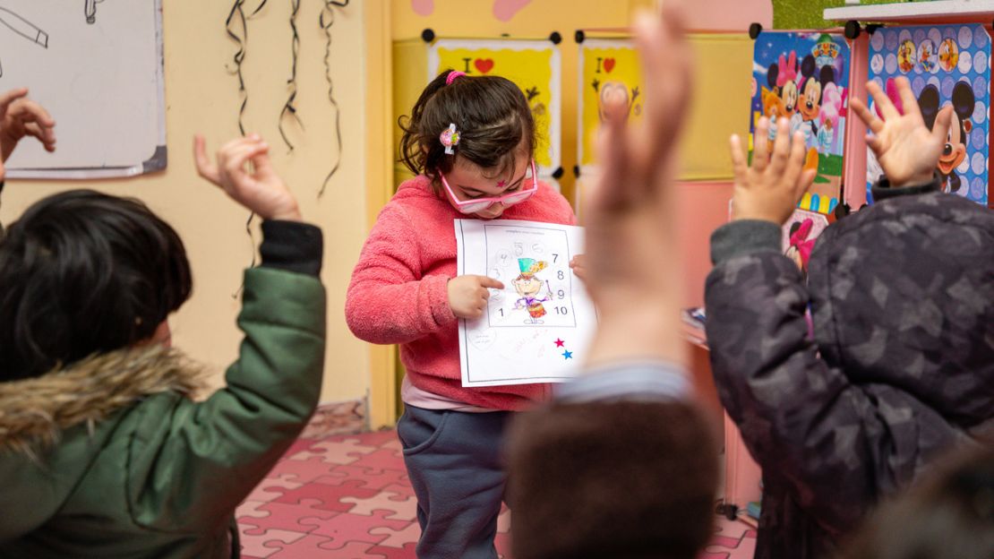 Une jeune fille montre un exercice aux autres élèves de sa classe