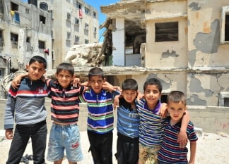 photo d'enfants devant des décombres