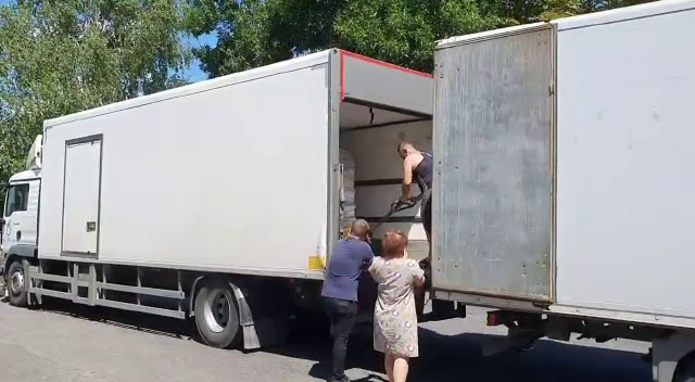Le « kiss » pour déplacer les marchandises entre deux camions à Ivanivske. © HI