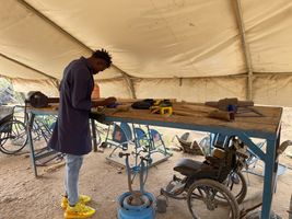 Un assistant technique fabrique et répare des aides à la mobilité dans un atelier de prothèses et d'orthèses du camp de réfugiés de Kakuma, au Kenya. © E. Sellers / HI