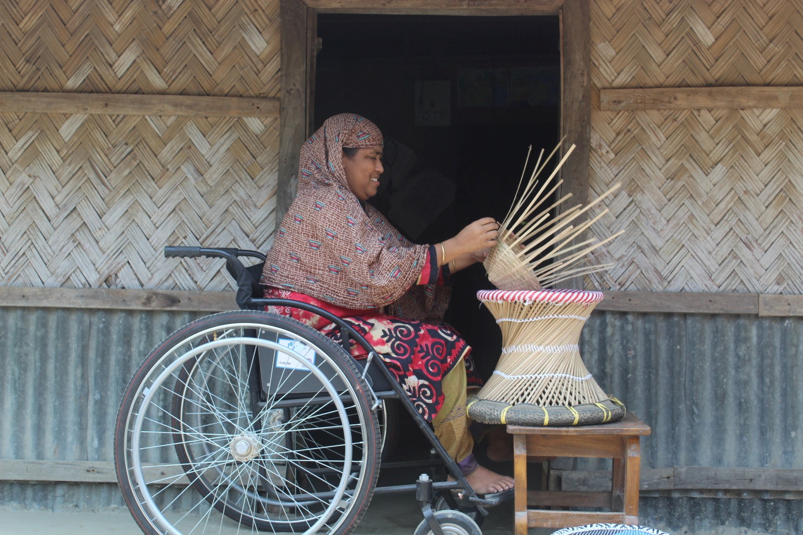 Sanowara B., 35 ans, tresse des paniers au Bangladesh. 2021 © HI