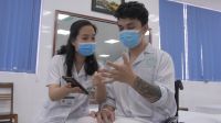 Een revalidatieprofessional toont een patiënt hoe hij de mobiele applicatie OpenTeleRehab in Vietnam moet gebruiken. 