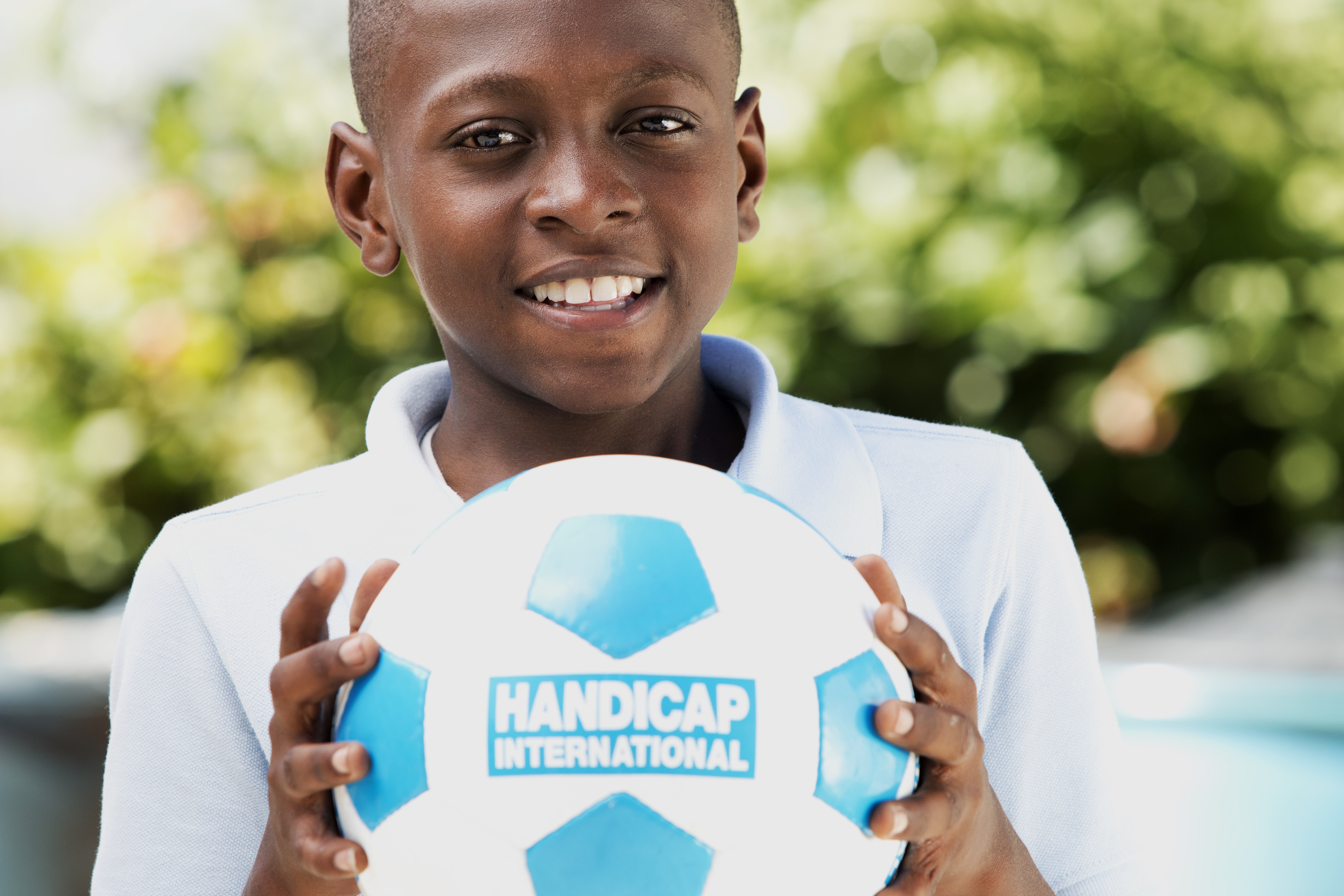 Garçon tenant un ballon de football Handicap International