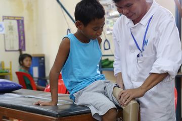 Un médecin auscultant un enfant. Image illustrant le legs particulier.