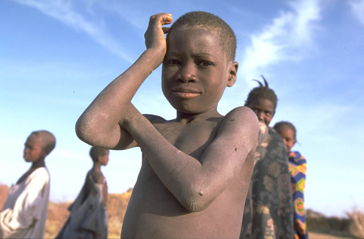 Un garçon du Sahel, quatre autres enfants sont à l'arrière-plan